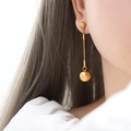 Minimalist gold tassel chain earrings with polished ball pendant on model - Gold Long Earrings