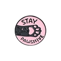 Macro view of Stay Pawsitive round enamel pin with black cat and pink background - Pink Cat Paw-STAY PAWSITIVE