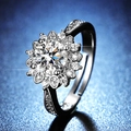 Close-up of a sunflower-shaped moissanite ring with side accent stones on a blue background - Y126 Sunflower Cluster Halo