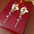 Detail of vintage beaded tassel earrings with orange and white charms on wood - Silver Ear Hook Coffee Style