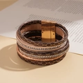 Détail d'un bracelet multicouche en cuir marron avec fermoir magnétique doré et strass - Bracelet-Marron