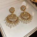 Makroaufnahme von Vintage-Goldohrringen mit Champagner-Strass und weißen Perlen auf Samt - Hohle Scheibe Champagner Diamant Perle Stil (25#)