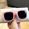 Detail view of pink matte foldable sunglasses for kids held by hand with storage pouch - Pink (Foldable)