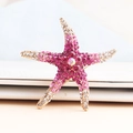 Sparkling gradient rhinestone starfish brooch with a large center gem in a gold finish - Rose Red