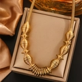 Dettaglio della collana a spirale dorata su portagioie con sfondo di seta - Stile a Navetta Industriale (E-54) / Oro