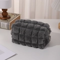 Macro shot of dark grey plush pencil case with textured square pattern and metal zipper - Gray