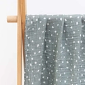 Sage green muslin baby blanket with white dots on a natural wooden hanger - Grey-Green Polka Dots (S152)