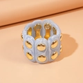 Detail of blue marble acrylic stretch bracelet with gold studs on a neutral prop - Blue