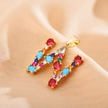 Macro shot of gold letter M pendant with colorful zircons on luxury champagne silk - Letter W