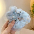 Detail of light blue daisy print sheer organza scrunchie held by hand in soft light - Blue Lace Double Layer Large