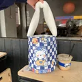 Dettaglio della borsa a secchiello a scacchi blu con manico di peluche e orsetto - Orso a Scacchi
