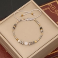 Detail of handmade natural stone beaded bracelet with adjustable woven rope strap - Gray