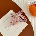 Détail macro de la pince à cheveux papillon évidée avec motifs rose violet et bordure dorée - Violet Métallique