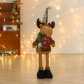 Close-up of plush reindeer doll in red and green plaid outfit with warm bokeh lighting - Elk