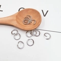 Detail of silver metal open jump rings for DIY jewelry making on a decorative wooden spoon - 0.9mm*6mm / Silver