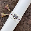 Detail van een handgeweven armband met kleurrijke strass, parelrand en een beertje bedel - Wit 2