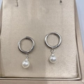 Close-up of minimalist silver hoop earrings with round white pearl pendants on display - Pearl Silver