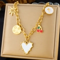 Close-up of golden necklace with white shell heart and cherry charms on a jewelry box - Heart Sun Cross Cherry Starburst Style (N3263)