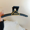 Matte black geometric hair claw clip featuring golden Power lettering in a triangle frame - Black Matte Triangle Style 2