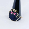 Macro detail of black enamel ghost cat charm with pink eyes and golden metal outlines - Ghost