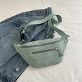 Light green corduroy waist bag with dual zippers on a blue denim jacket background - Light Green