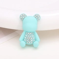 Macro shot of light blue bear charm with sparkling rhinestones for shoe decoration - Green Painted Bear