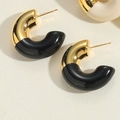 Macro di orecchini a C placcati oro con smalto nero su superficie materica di design - Stile Smalto Nero