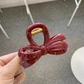 Detail of burgundy resin bow hair claw clip showing polished finish and metal spring - Approx. 8cm / Burgundy