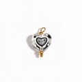 Detailed view of heart-shaped glass bead with black and white patterns and gold loop - Transparent Black & White Concentric Circles (Style 13)