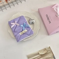 Detalle de la funda de pasaporte acolchada morada con lazos y textura de tela suave - Cuadros Púrpura Claro