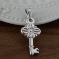 Pendentif clé en acier inoxydable argenté avec motif floral sur fond en bois - Clé / Acier