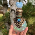 Decoratieve glazen toverdrankfles met regenboogschilfers en blauwe hartvormige stop - Wit