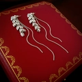 Gros plan de boucles d'oreilles vintage à pampilles en zircons sur un écrin de luxe rouge - Tige en Argent - Boucles d'Oreilles à Pampilles en Épis de Blé Argenté