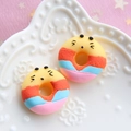 Macro shot of colorful resin donut charms with cute chick faces for DIY crafts - Yellow Base - Orange Blue Pink