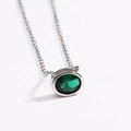 Detailed view of an oval green emerald pendant with a polished silver chain on white background - Style 3 Silver (Oval Shape)