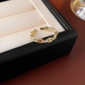 Detailansicht des goldenen Schweinenasen-Rings mit Zirkonia auf einer Schmuckschatulle - Zirkonia Ketten-Design-Stil / Gold