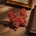 Broche papillon vintage avec cristaux rouges et finition dorée sur bois sombre - Rouge