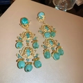 Detailed macro view of vintage gold hollow flower earrings with teal resin beads and crystals - Flower Ear Clip Pair / Teal