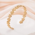 Elegant gold-tone stainless steel open bangle featuring continuous flower pattern design - Flower Shape / Gold