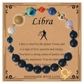 Handmade Libra zodiac bracelet with matte black beads and a gold star charm on a kraft card - Libra