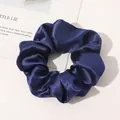 Macro view of silky navy blue satin scrunchie showing glossy texture and soft fabric folds - Navy Blue
