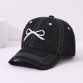 Détail d'une broderie nœud blanc sur casquette de baseball noire avec coutures blanches - 50-54cm / Noir