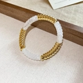 Dettaglio di maglie ritorte in acrilico e metallo dorato su un bracciale a perline - Stile Giunzione a Spirale / Bianco