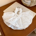 Gros plan d'un chouchou blanc brodé ajouré sur un livre ancien avec décor floral - Chouchou à Broderie Creuse Blanc (35#)