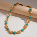 Dettaglio della collana retrò dorata con maglie triangolari e pietre turchesi incastonate - Collana-Blu