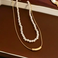 Detail van de dubbellaagse ketting met witte parels en een goudkleurige hanger - 2-delige Gouden Parelkettingset