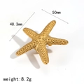 Goldener Seestern-Ring aus Edelstahl mit 50mm Größe und 8,2g Gewicht auf weißem Grund - Seestern-Ring (TR60467) / Gold