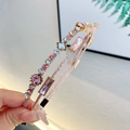 Due eleganti cerchietti a doppio strato con strass colorati tenuti in mano con cura - Rosa