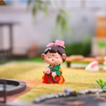 Cartoon Tang Dynasty lady figurine in red hanfu holding a fan among miniature garden scenery - Gentle Breeze Small