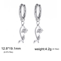 Boucles d'oreilles créoles en acier argenté avec breloques fleurs évidées sur fond blanc - Lotus des neiges